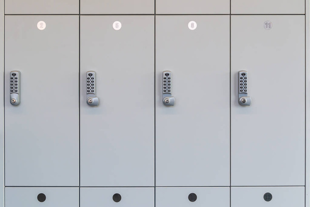 Λευκά ντουλάπια αποδυτήρια με ηλεκτρονικό έλεγχο πρόσβασης σε ένα δημόσιο δωμάτιο όπως η ντουλάπα σε ένα δωμάτιο που αλλάζει. - Φωτογραφία, εικόνα