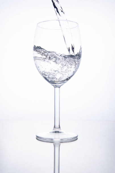 The glass is filled with clear transparent water. - Фото, изображение