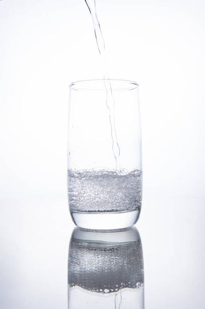 The glass beaker is filled with clear transparent mineral water. - Valokuva, kuva