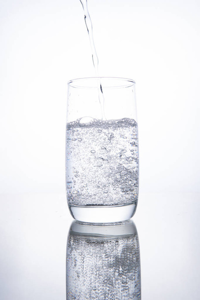 The glass beaker is filled with clear transparent mineral water. - Foto, Bild
