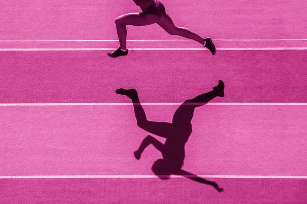 Одна бігунка біжить у силуеті на фоні стадіону. Фільтр рожевого кольору
 - Фото, зображення