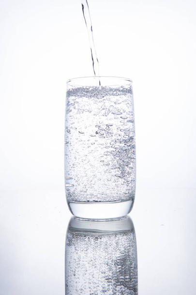 The glass beaker is filled with clear transparent mineral water. - 写真・画像