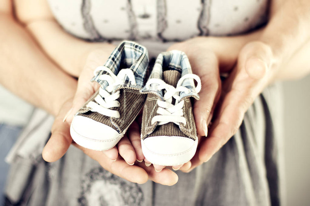 Newborn Baby Sneakers in Family Hands, Parents Couple New Born Booties - Photo, image