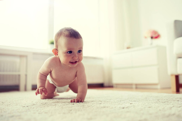 malé dítě v plenkách plazí po podlaze doma - Fotografie, Obrázek
