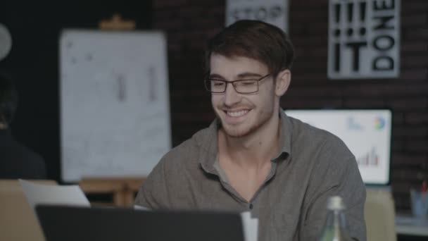 Homem de negócios sorrindo procurando papel de documento no local de trabalho no escritório escuro - Filmagem, Vídeo