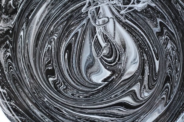 abstract image mixing of two colors. The texture of the circles of white and black paint - Photo, Image