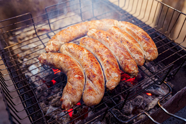 Grilled sausage on the picnic flaming grill - Foto, imagen