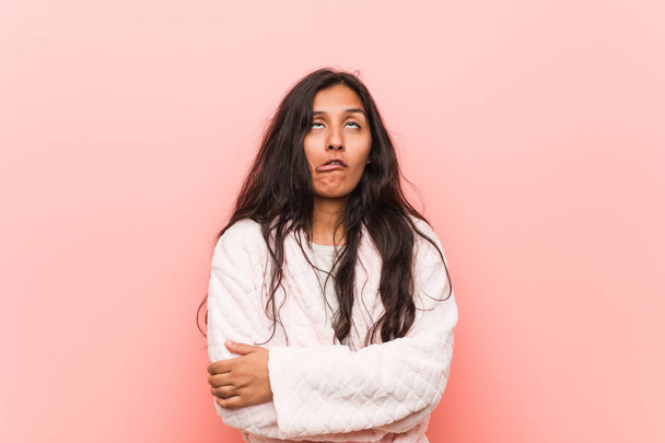 Young indian woman wearing pajama tired of a repetitive task. - 写真・画像