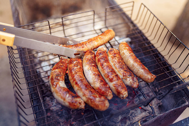 Grilled sausage on the picnic flaming grill - Photo, Image