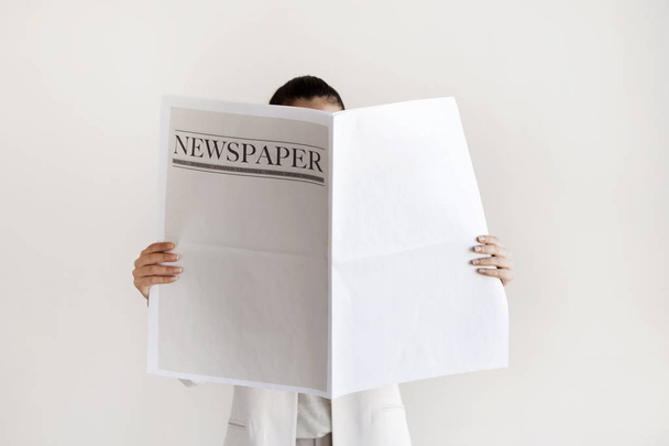 Mulher lendo jornal no fundo branco
 - Foto, Imagem