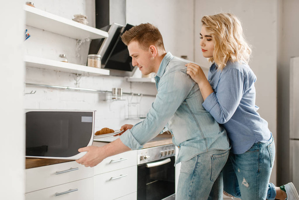 Love couple prepares food for the romantic dinner. Man and woman cooking on the kitchen together. Happy lifestyle, beautiful relationship - Φωτογραφία, εικόνα