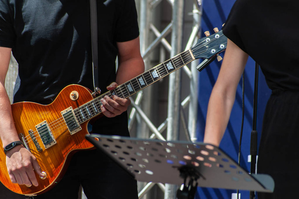 Jonge man in zwarte neutrale t-Short speelt gele elektrische gitaar  - Foto, afbeelding