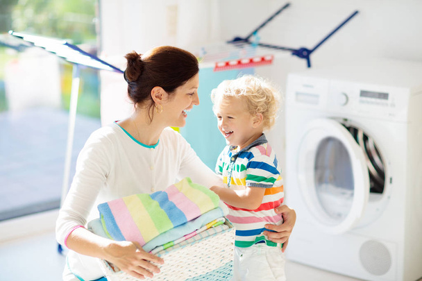 Família na lavanderia com máquina de lavar roupa
 - Foto, Imagem