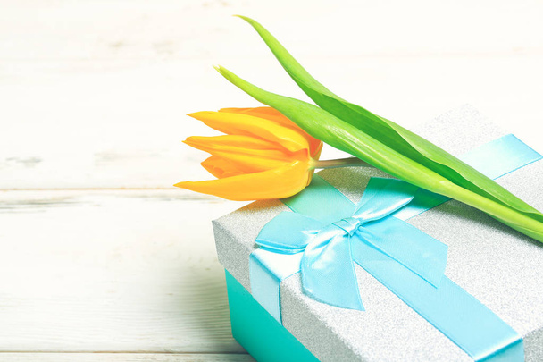 greeting card yellow tulips on turquoise gift box on a white wooden background. Scandinavian style, place for text. - Foto, Imagem