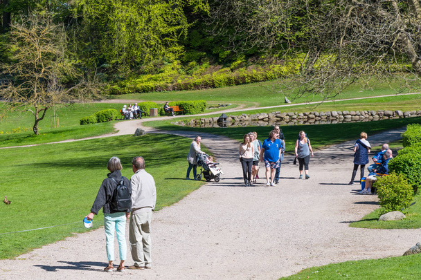 people walking in the park at Liselund palace in denmark on a sunny spring day - Photo, image