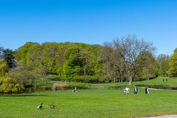 people walking in the park at Liselund palace in denmark on a sunny spring day - Photo, Image