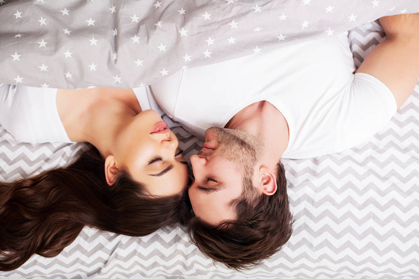 glückliches Paar, das Spaß im Bett hat. intime sinnliche junge Paar im Schlafzimmer genießen einander - Foto, Bild