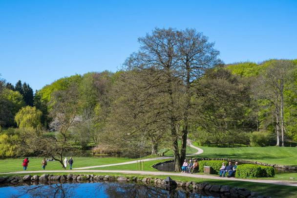 people walking in the park at Liselund palace in denmark on a sunny spring day - Photo, image