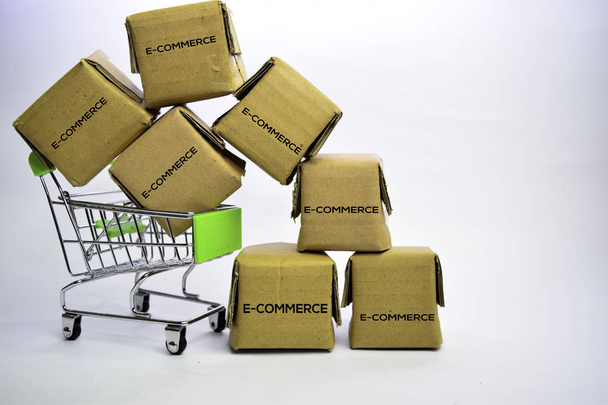 E-Commerce Teksti pienissä laatikoissa ja ostoskorissa. Käsitteet verkkokaupoista. Eristetty valkoisella pohjalla
 - Valokuva, kuva
