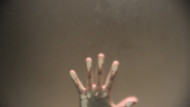 One hand behind a frosted glass and some weird movement up to down. - Imágenes, Vídeo