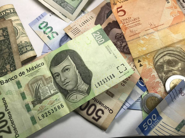 Muchos billetes mixtos de peso mexicano repartidos sobre un escritorio de madera
 - Foto, imagen