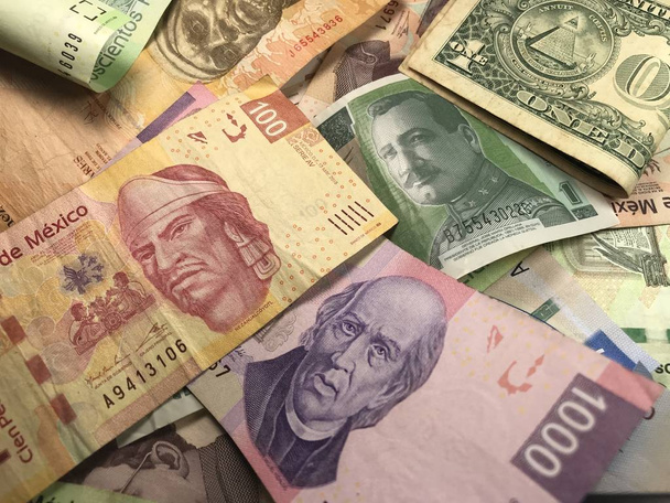 Muchos billetes mixtos de peso mexicano repartidos sobre un escritorio de madera
 - Foto, Imagen