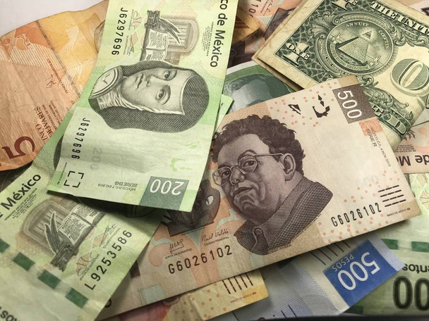 Muitas contas de peso mexicanas mistas espalhadas por uma mesa de madeira
 - Foto, Imagem