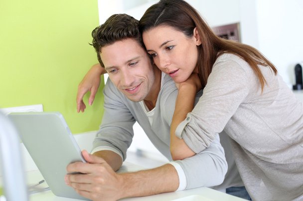 Cheerful couple looking at internet on tablet - Foto, Imagem