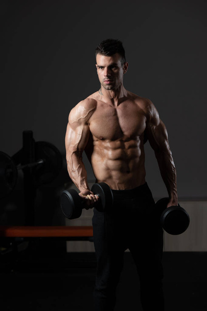Muscular Man Exercising Biceps With Dumbbell - Photo, image