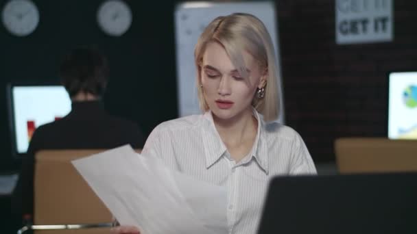 Teleurgesteld zakenvrouw gooien document front laptop in donker kantoor - Video