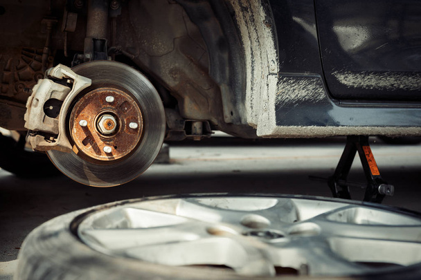 car disc brake during the wheel tire repair. Disc brake of the car during the maintenance at auto service garage. - Fotografie, Obrázek