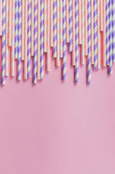 row of drinking straws with stripe and polka dot design border on pink background.prohibition of the use of plastic.Minimalism concept. Pop art style.Paper straws used for drinking water or soft - Photo, Image