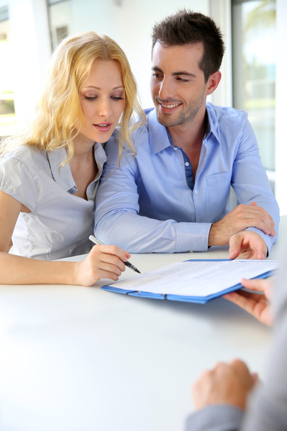 Cheerful couple signing property contract with real-estate agent - Photo, image