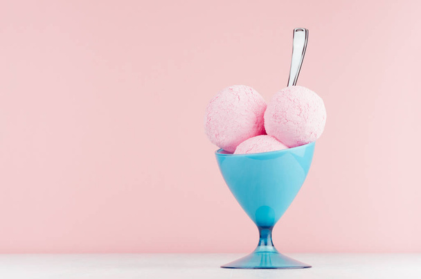 Sweet pink strawberry ice cream in elegant blue ice-cream bowl with spoon on white wood table and pastel pink wall. - Photo, image