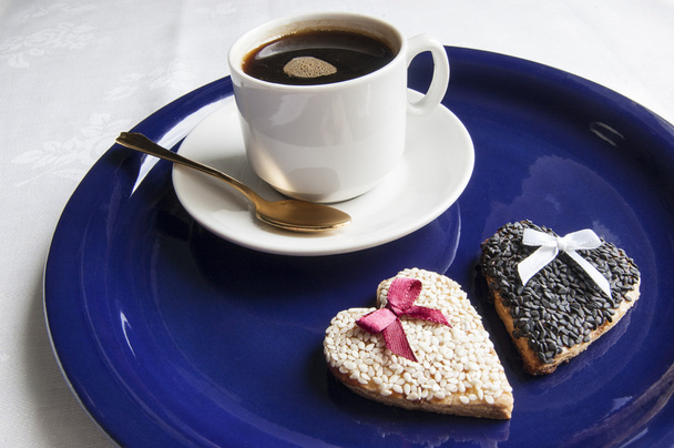 Весільне печиво з чашкою кави на синій тарілці
 - Фото, зображення