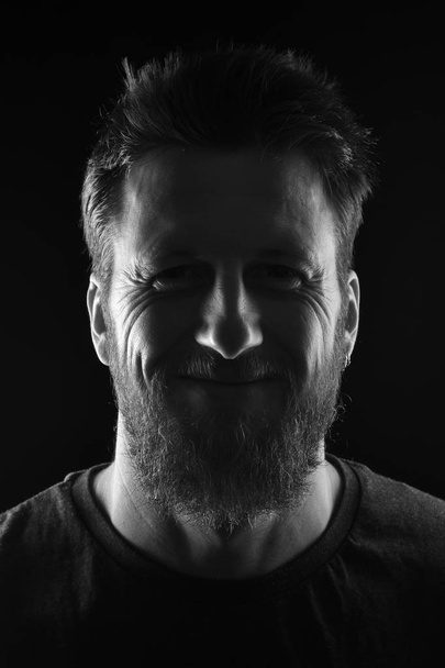 portrait of a smiling man on black background - Foto, afbeelding