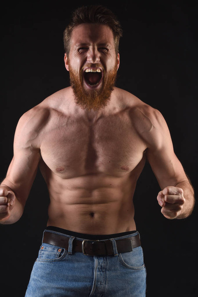 angry shirtless man in black background - Foto, imagen