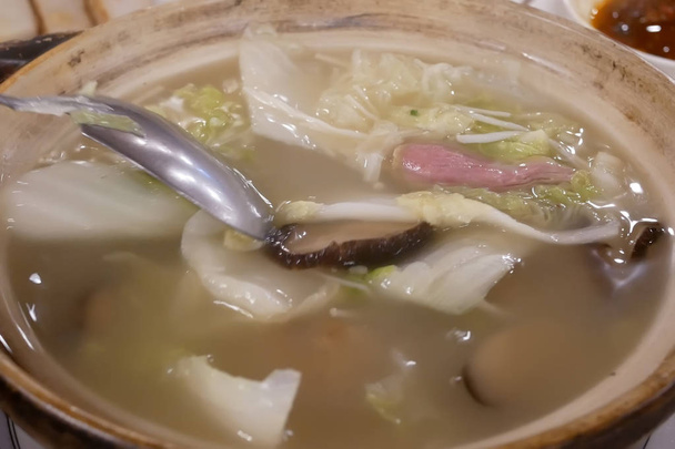 Movimiento de la gente revolviendo sopa en un tazón dentro del restaurante chino
 - Foto, imagen