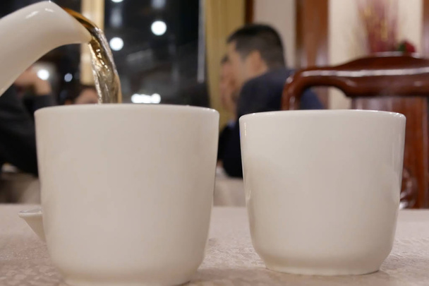 Movimiento de personas que vierten té caliente dentro del restaurante chino
 - Foto, imagen