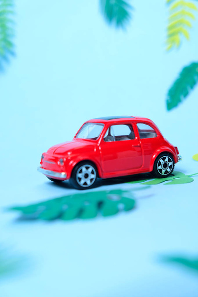 small toy red car driven by summer - Foto, afbeelding