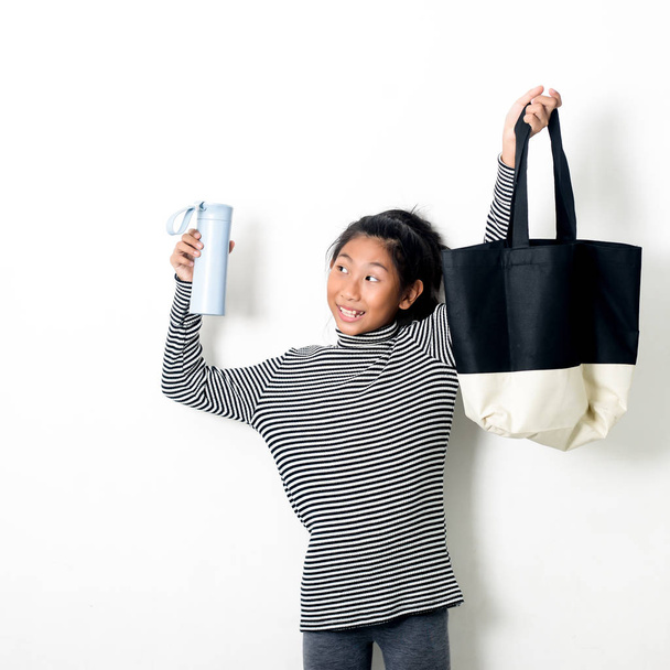 Asian girl holding fabric handbag and water drink bottle eco was - Фото, изображение