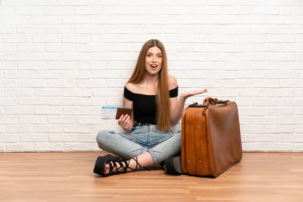 Traveler woman with suitcase and boarding pass with shocked facial expression - Photo, Image