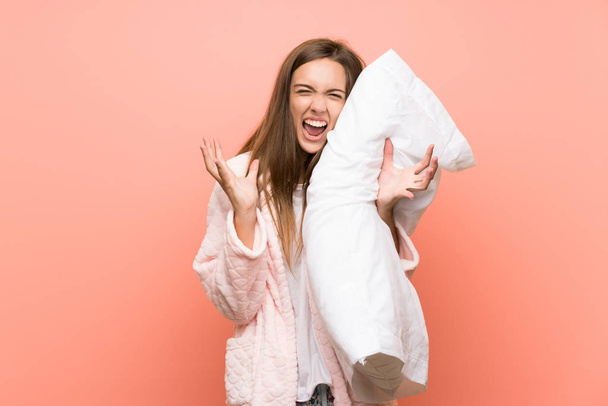 Young woman in dressing gown over pink wall unhappy and frustrated with something - Photo, Image