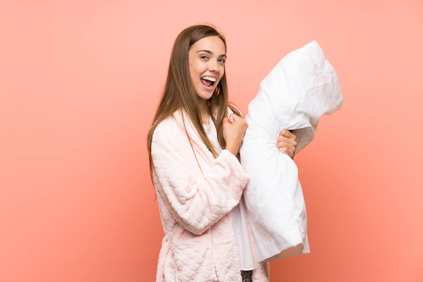 Young woman in dressing gown over pink wall celebrating a victory - Photo, Image