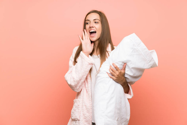 Young woman in dressing gown over pink wall shouting with mouth wide open - Photo, Image