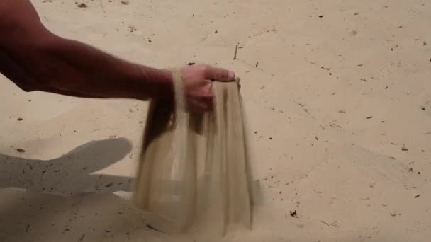 Handen van de mens SIFT zand op een zandduin in het natuurpark van Oekraïne. De textuur van zand op de rivierduin. - Video