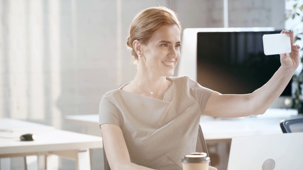 feliz mujer de negocios hablando selfie y sonriendo en la oficina
  - Metraje, vídeo