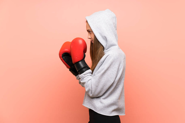 Mladý sport žena přes izolované růžové pozadí s boxerskými rukavicemi - Fotografie, Obrázek