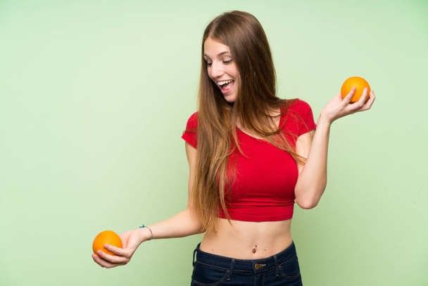 オレンジを持つ長い髪の若い女性 - 写真・画像
