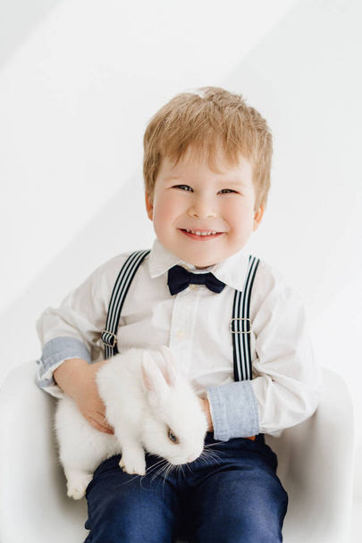 Sonriente niño posando con retrato de conejo
 - Foto, imagen